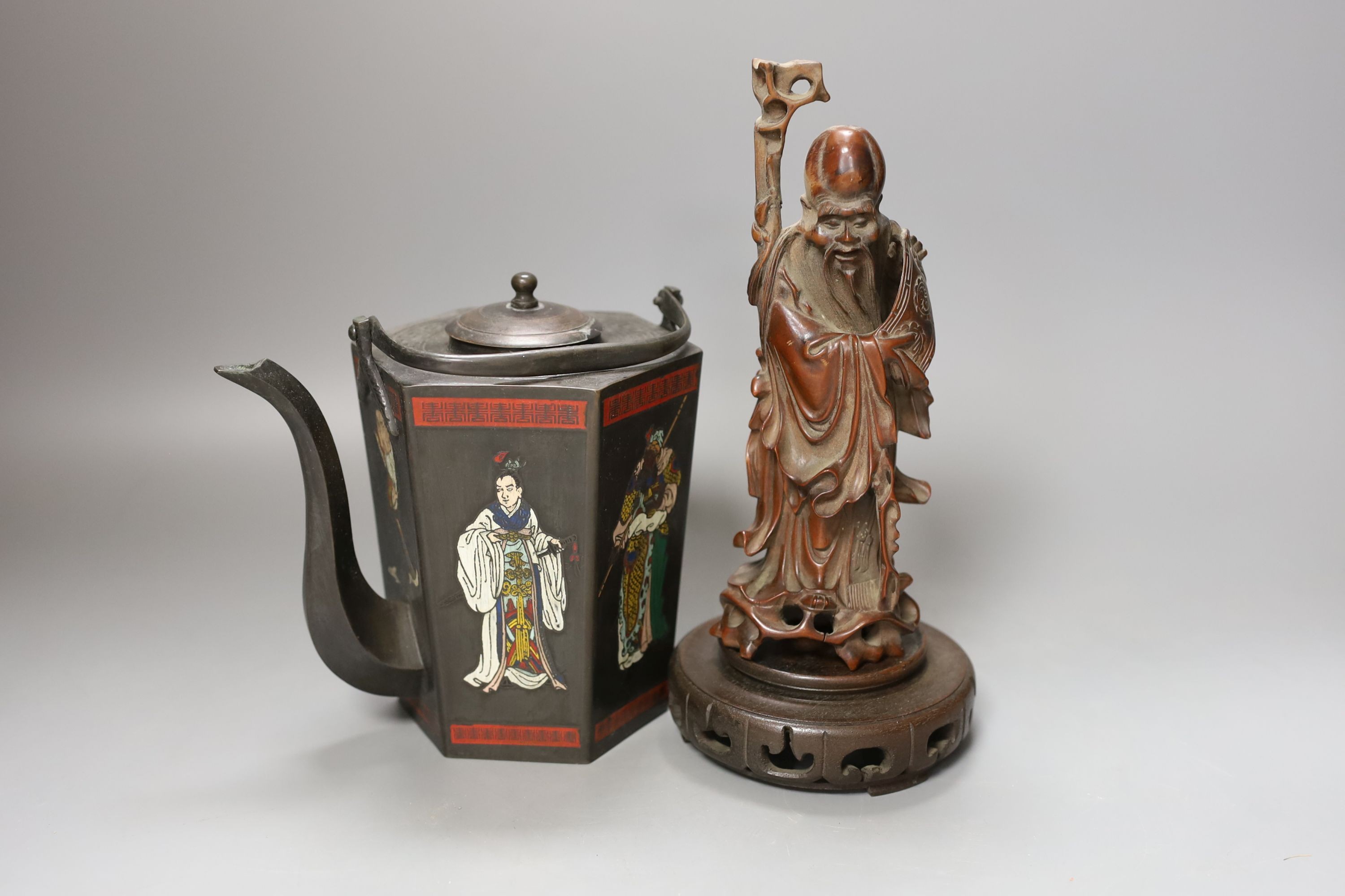 A Chinese carved hardwood figure of Shao Lao on hardwood stand and a similar painted metal teapot, figure 24cm including stand